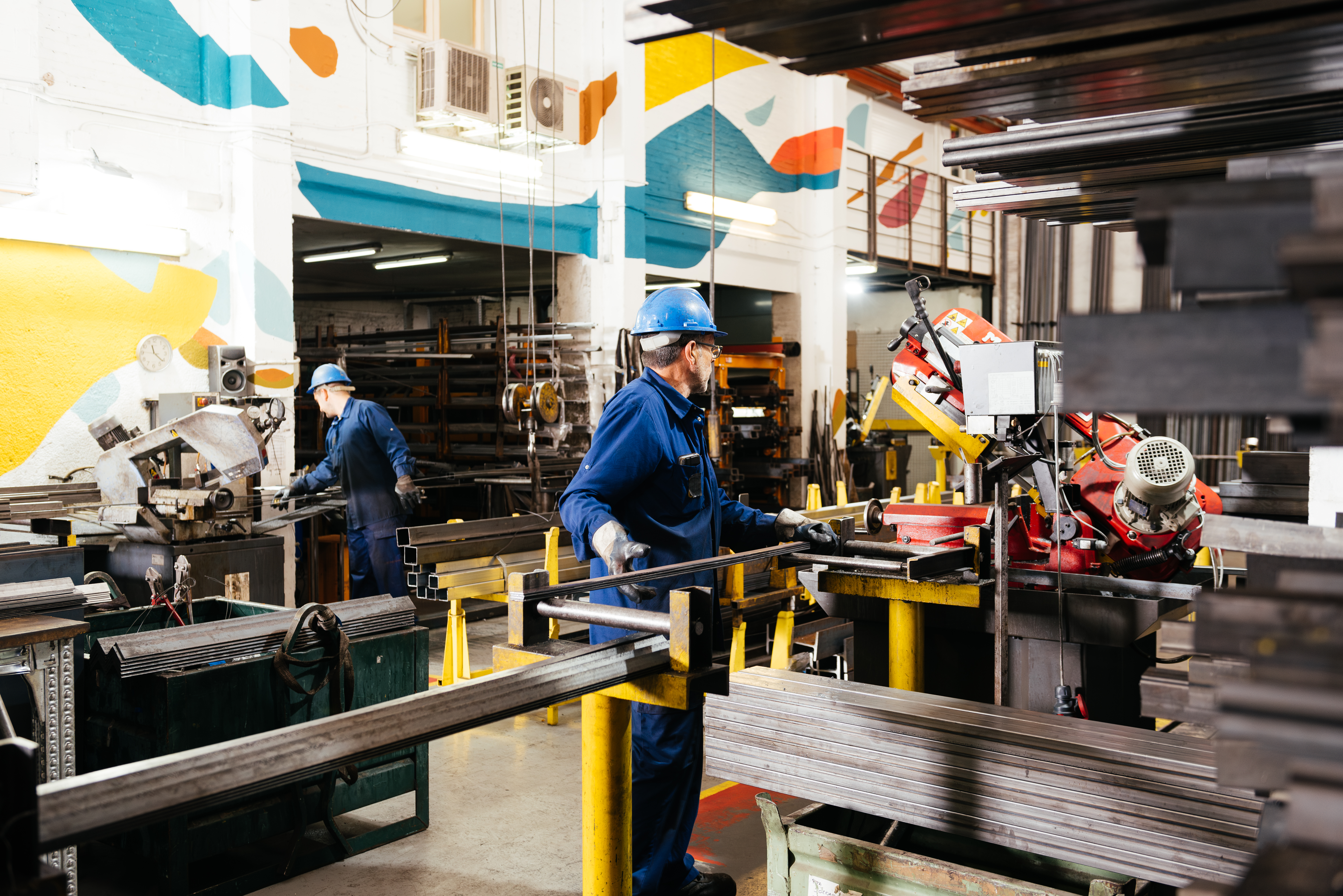 Anonymous male factory workers working in industrial metal workshop Anonymous male factory workers working in industrial metal workshop